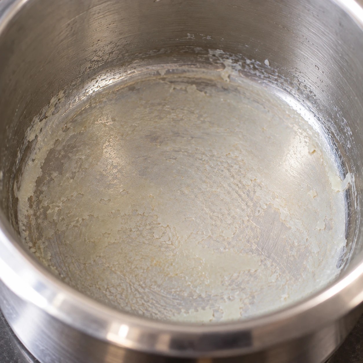 Sediment settled at the bottom of a steel milk vessel